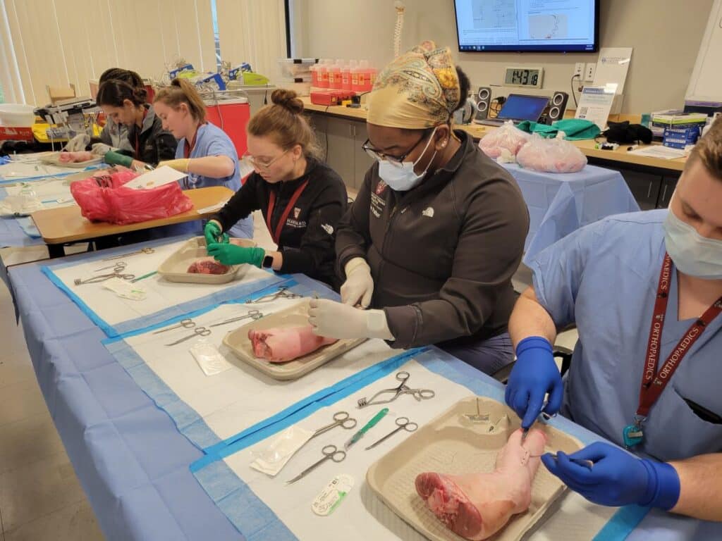 Learners practice suturing at the Orthopedics Bootcamp.